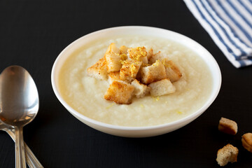Homemade Cauliflower Soup with Croutons and Oil, side view.