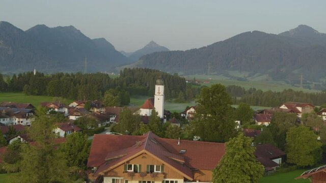 Idyllic Wallgau village in Bavarian valley with St. Jakob church, Alps in background