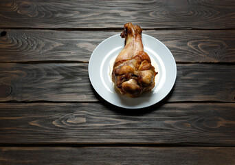 Roasted turkey leg on dark wooden background. Top view