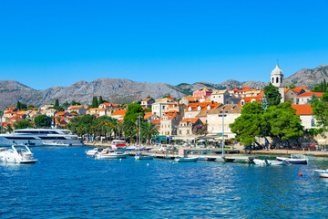 Naklejka premium A picturesque panoramic view of the ancient city of Cavtat in Croatia, surrounded by the Adriatic Sea and mountains, an embankment with moored pleasure yachts, motor boats and liners
