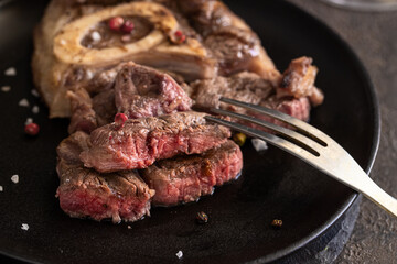 Ossobuco alla Milanese on dark plate with spices.