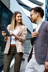 Man and woman talking in urban city center in business style working together, smiling