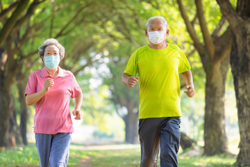 Asian Senior couple in face mask and jogging in the park