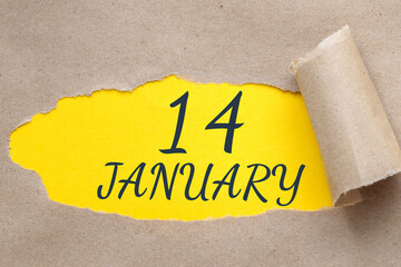 january 14. 14th day of the month, calendar date.Hole in paper with edges torn off. Yellow background is visible through ragged hole.Winter month, day of the year concept