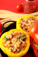 Concept of tasty food with stuffed pepper on red background