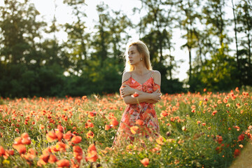 girl in a pink dress in a field with red poppies