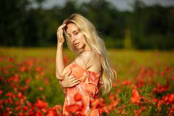 girl in a pink dress in a field with red poppies