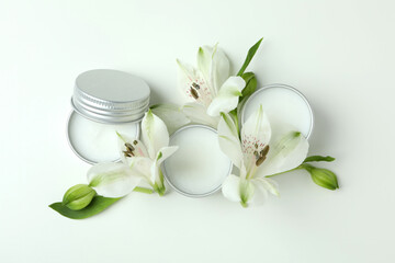 Eco lip balm and flowers on white background