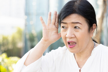 excited old asian senior woman suffering from hard of hearing, hearing impair, deafness sickness