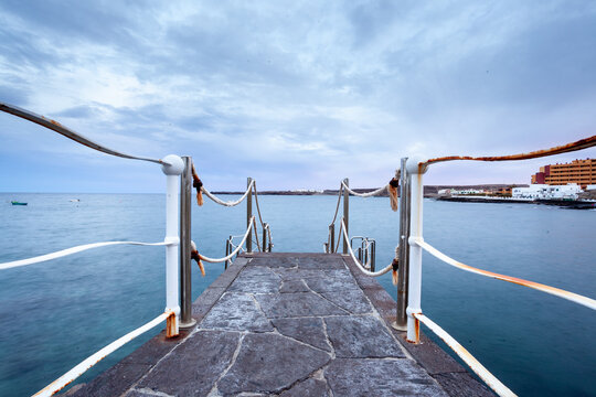 Pier with metal handrails on a cloudy day