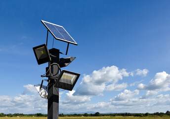 Photovoltaic panel systems and hd floodlights on black metal pole in public park, soft and...