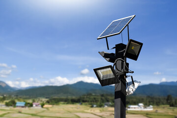 Photovoltaic panel systems and hd floodlights on black metal pole in public park, soft and selective focus.