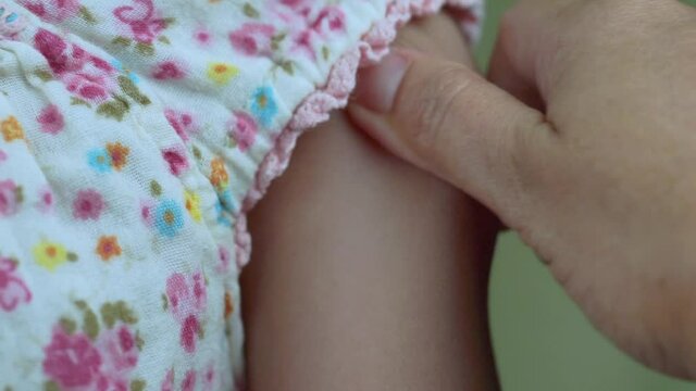 Asian mother and child girl playing pinch arm, Mom pinches the skin on the kids arm.