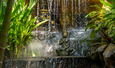 Statue in a garden waterfall at Wat Saket Temple in Bangkok Thailand