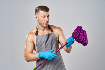 man in apron with mop in hand posing housework