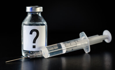 Vaccine bottle with hypodermic syringe needle near, question mark on label, black background - unknown side effects of experimental treatment concept