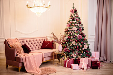 Warm cozy beautiful modern room design in gentle light colors decorated with a Christmas tree and decor elements for the new year