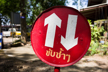Circle red sign for slowly driving notice with Thai language.
