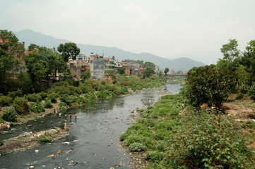 Childrens crossing river full of waste in Kathmandu 