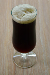 A brown ale in a glass on the table
