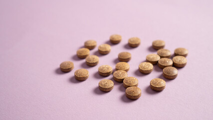 Biologically active additives. Biologically active supplement pills. Brown pills on violet