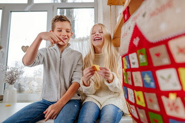 Children reading tasks from Christmas handmade advent calendar