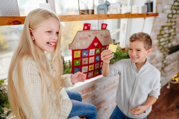 Children reading tasks from Christmas handmade advent calendar