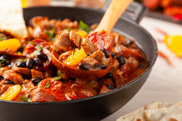 Pork stew with chorizo and black beans. Served with orange and seasoned with hot chili peppers. Perfect with tortillas.