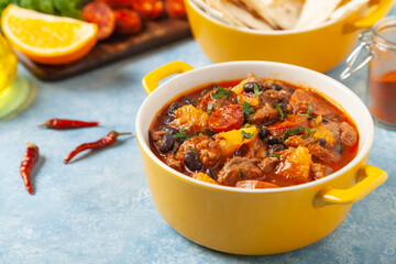 Pork stew with chorizo and black beans. Served with orange and seasoned with hot chili peppers....