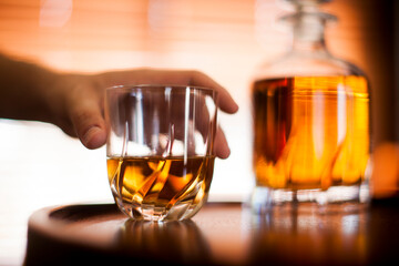 Human hand - Whiskey glass close up in a dark bar setting. Selective focus on the glass. Copy space.High quality photo