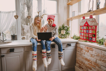 Boy and girl making video call using laptop at Christmas time