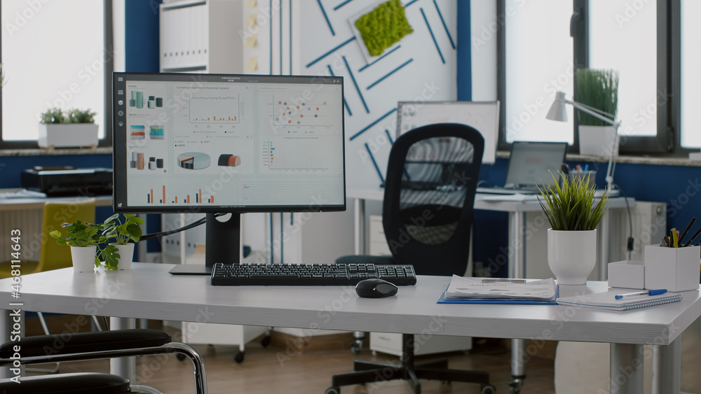 Poster computer in empty workplace with graphs on screen and wheelchair for disabled workers. business offi