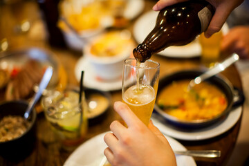 Group of people cheering with caipirinha drink glasses - Happy young friends enjoying lunch in a bar with food e drink -- Youth concept - High quality photo