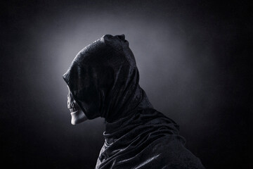 Grim reaper over dark misty background