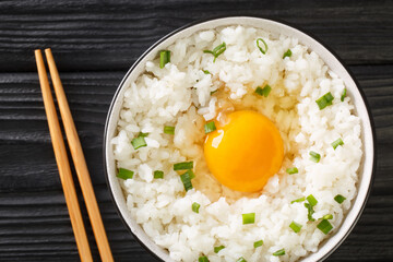 Tamago Kake Gohan Recipe Egg Over Rice close up in the bowl on the table. Horizontal top view from above