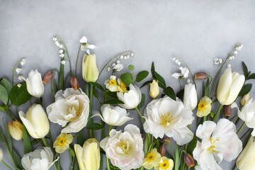 Spring blossoming white tulips, light yellow daffodils and lily of the valley flowers festive background, bright springtime bouquet floral card