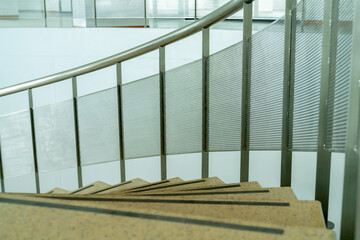 The curved steel staircase goes up to the second floor. with stainless steel handrails The stairs are marble.