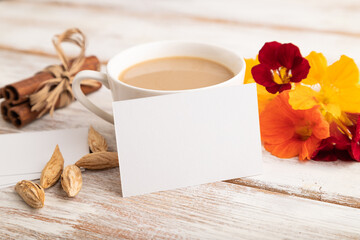 Naklejka na ściany i meble White paper business card mockup with orange nasturtium flower and cup of coffee on white wooden background. side view, copy space.