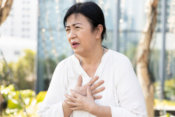 sick old senior woman suffering from GERD or acid reflux