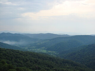 Panorama of cloudy sky over endless mountain ranges covered with a green carpet of Transcarpathian forests.