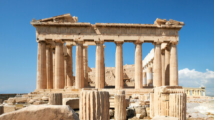 Parthenon temple on a bright day with blue sky. Panoramic image taken in Acropolis hill in Athens, Greece. Classical ancient Greek civilization landmark, famous place, panoramic travel background.
