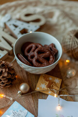 Living room with Christmas decorations. Cup of hot cocoa with marshmallows, cookies on wooden tray. Christmas tree, gift boxes, cozy armchair, pillows, fireplace. Christmas lights.