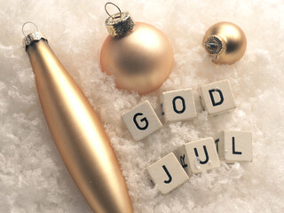 God Jul, Scandinavian Merry Christmas, wooden blocks with golden Christmas baubles in snow