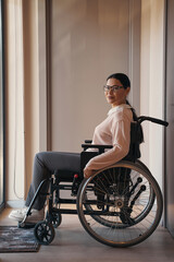 Fototapeta na wymiar Elegant woman who is using wheelchair indoors