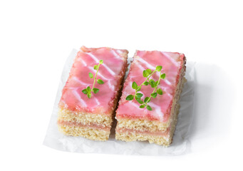 Slices of sponge cake with pink ganache isolated on white