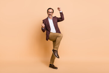 Fototapeta na wymiar Full length body size view of attractive cheerful crazy man dancing having fun isolated over beige color background