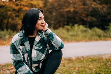 Portrait of young woman in the woods during the colourful fall season. happy girl posing in the forest.