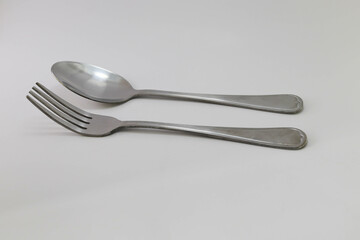 Stainless steel or silver spoon and fork isolated on white background closeup.