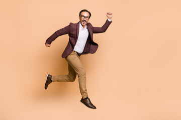 Fototapeta na wymiar Full length body size view of attractive cheery man jumping running start economist career isolated over beige color background