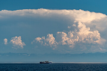 Ship on Lake Baikal under cumulus clouds